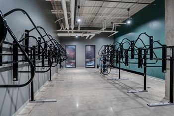 A room with a row of bike racks and paintings on the wall